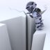 A small, futuristic robot peering into a deep crack on a vast, monochromatic surface.