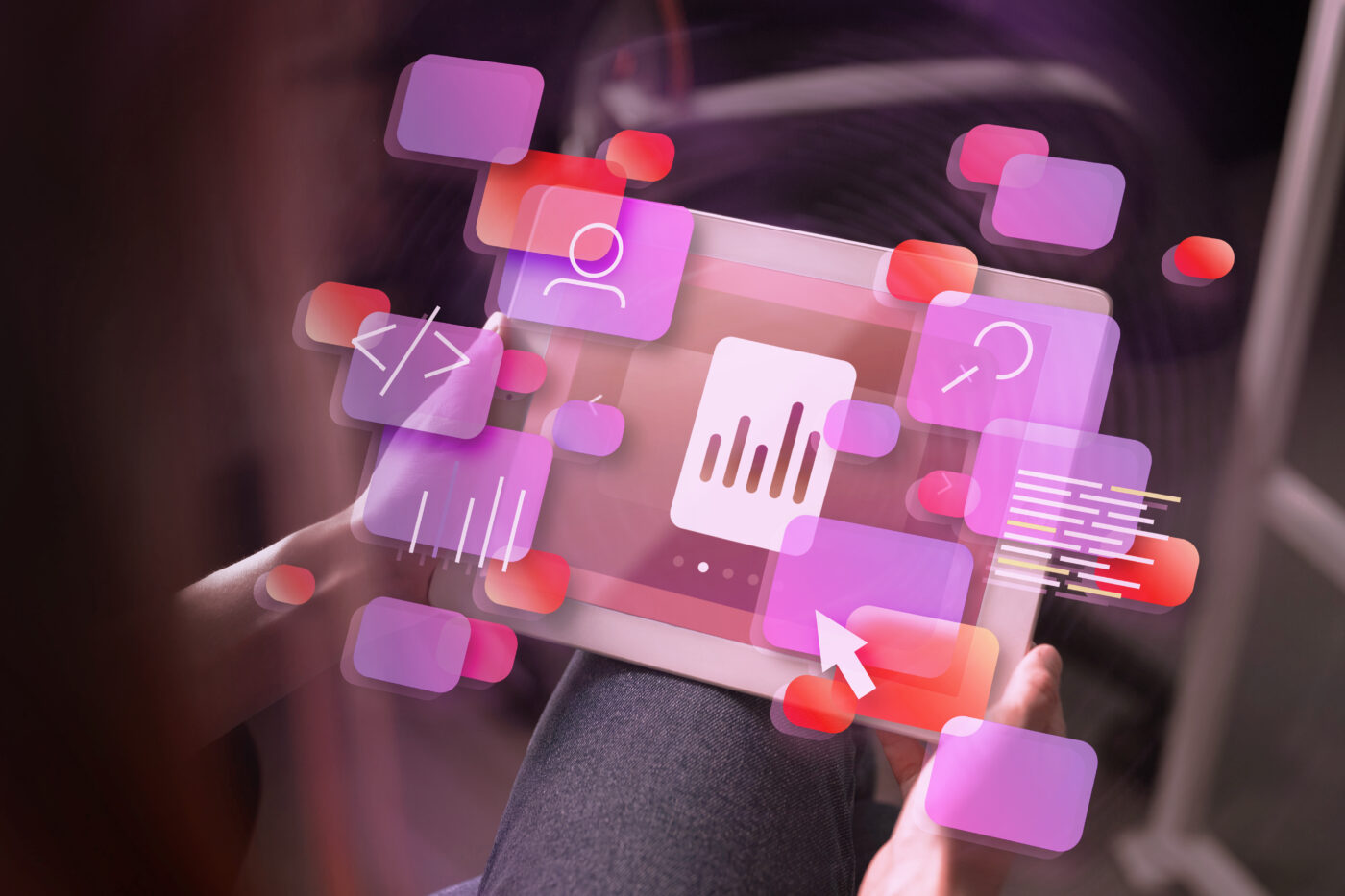 A person interacting with a tablet displaying floating pink and red UI icons, representing analytics, coding, and user interface elements.